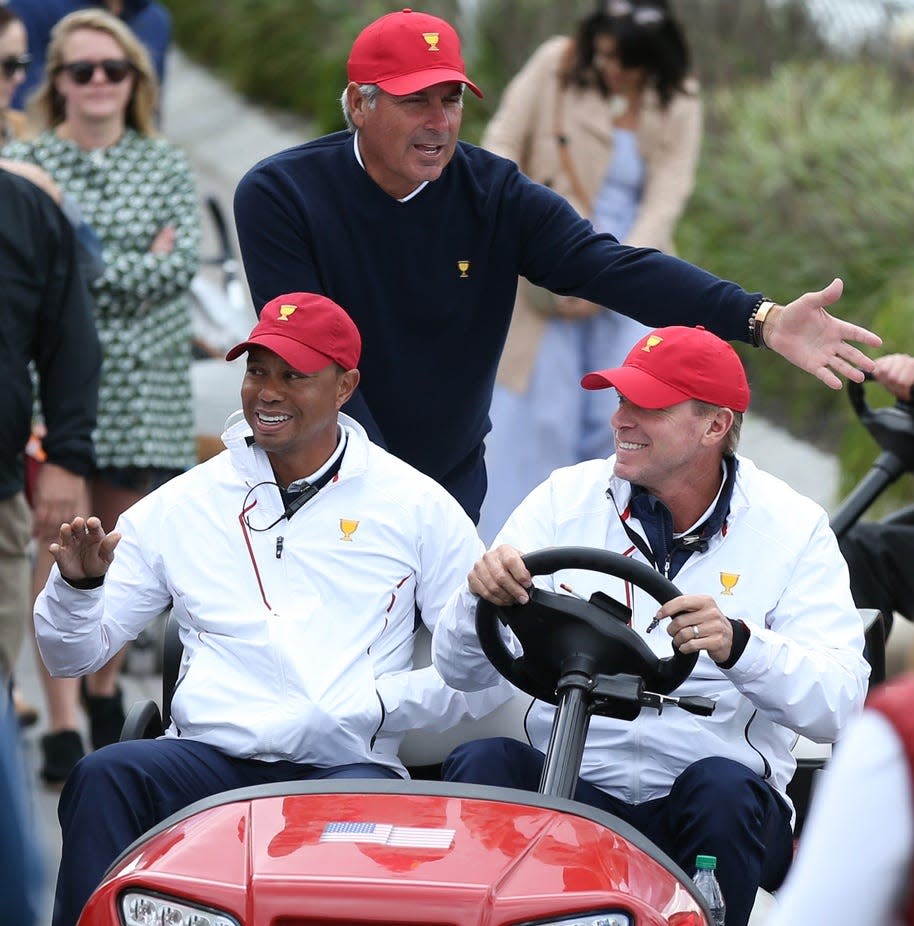Assistant captains to the U.S. team Tiger Woods and Fred Couples and Captain of the U.S. team Steve Stricker greet fans while riding in a cart during foursomes matches at the President’s Cup.
