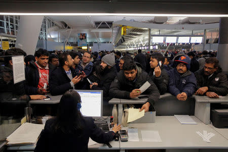 Passengers surround a customer service desk for Air India following a series of delays in the departure area of Terminal 4 at John F. Kennedy International Airport in New York City, U.S. January 7, 2018. REUTERS/Andrew Kelly