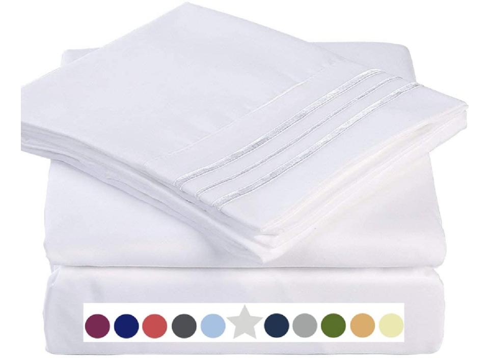 A set of white cooling sheets atop a mattress, with a color scale beneath.