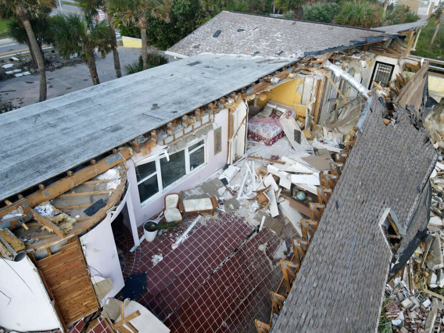 <em>FILE – A bed and chairs are seen inside a home that half collapsed after the sand supporting it was swept away, following the passage of Hurricane Nicole, Saturday, Nov. 12, 2022, in Wilbur-By-The-Sea, Fla. (AP Photo/Rebecca Blackwell)</em>