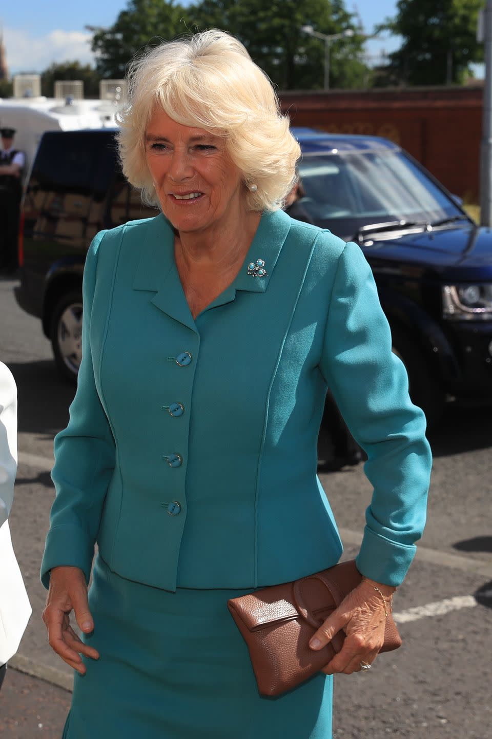 <p>During a trip to Northern Ireland, the Duchess adorned a bright blue suit with a shamrock pin. She also carried a small brown clutch for her visit to the Belfast Welcome Organisation, which provides support to people affected by homelessness.</p>