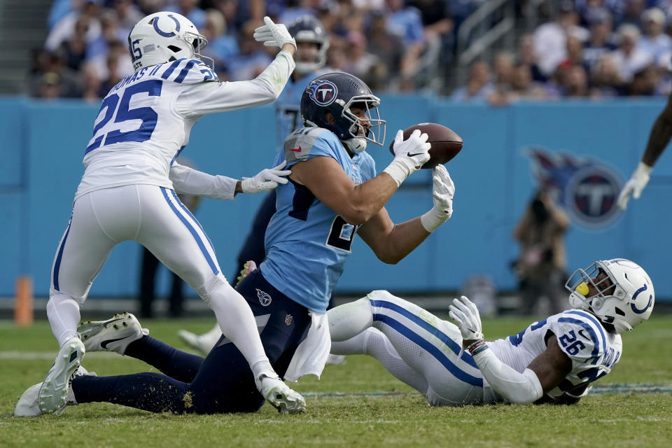 Tennessee Titans tight end Austin Hooper, center, catches a pass as Indianapolis Colts safety Rodney Thomas II (25) and safety Rodney McLeod Jr. (26) defend during the second half of an NFL football game Sunday, Oct. 23, 2022, in Nashville, Tenn. (AP Photo/Mark Humphrey)