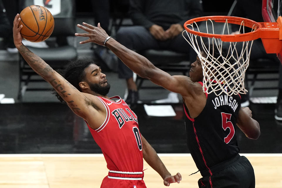 Chicago Bulls guard Coby White, left, goes up for a dunk against Toronto Raptors forward Stanley Johnson during the first half of an NBA basketball game in Chicago, Thursday, May 13, 2021. (AP Photo/Nam Y. Huh)