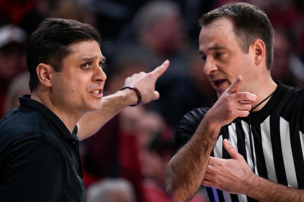 UC Bearcats coach Wes Miller chats with an official during their 74-72 win over Kansas State. UC won despite shooting just eight free throws compared to 25 for the Wildcats.