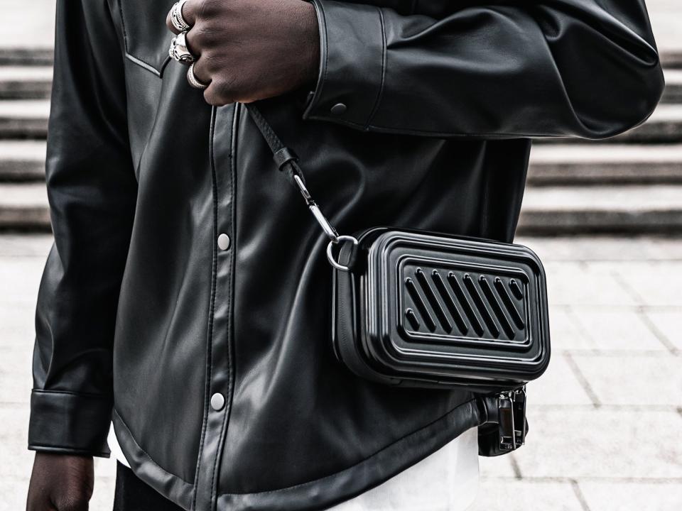 A man in a black shirt with a black bag