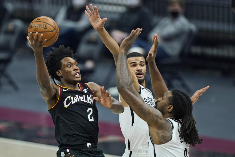 Cleveland Cavaliers' Collin Sexton, left, drives to the basket against Brooklyn Nets' DeAndre Jordan, right, and Timothe Luwawu-Cabarrot during the first half of an NBA basketball game Friday, Jan. 22, 2021, in Cleveland. (AP Photo/Tony Dejak)