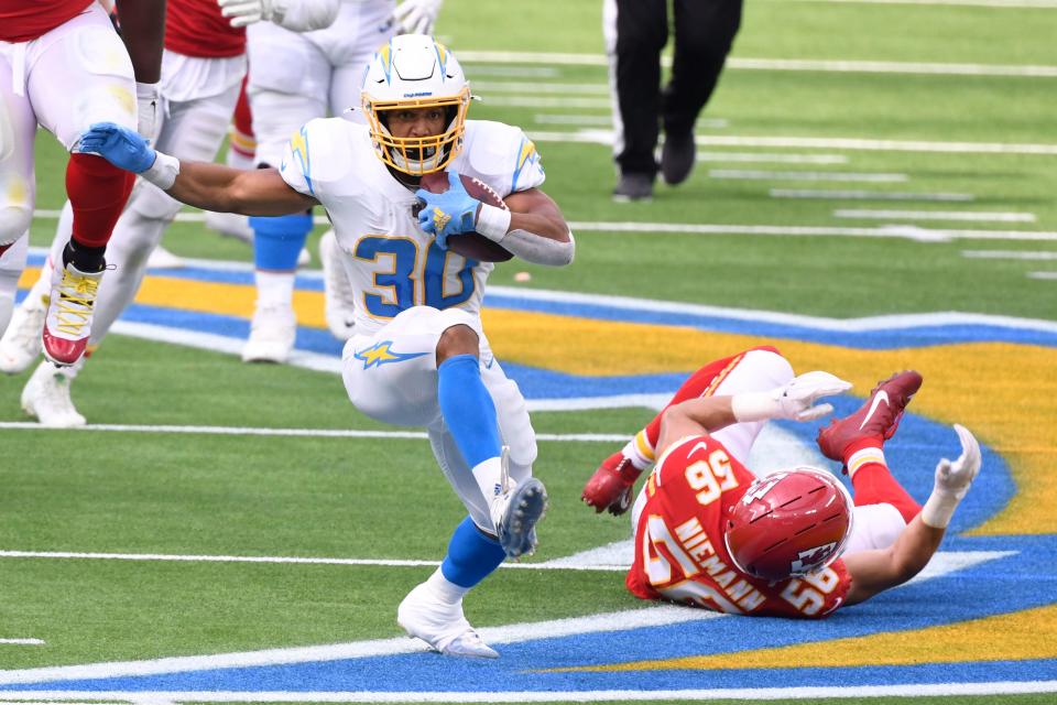 Los Angeles Chargers running back Austin Ekeler (30) breaks away from Kansas City Chiefs linebacker Ben Niemann (56) during the second quarter at SoFi Stadium.