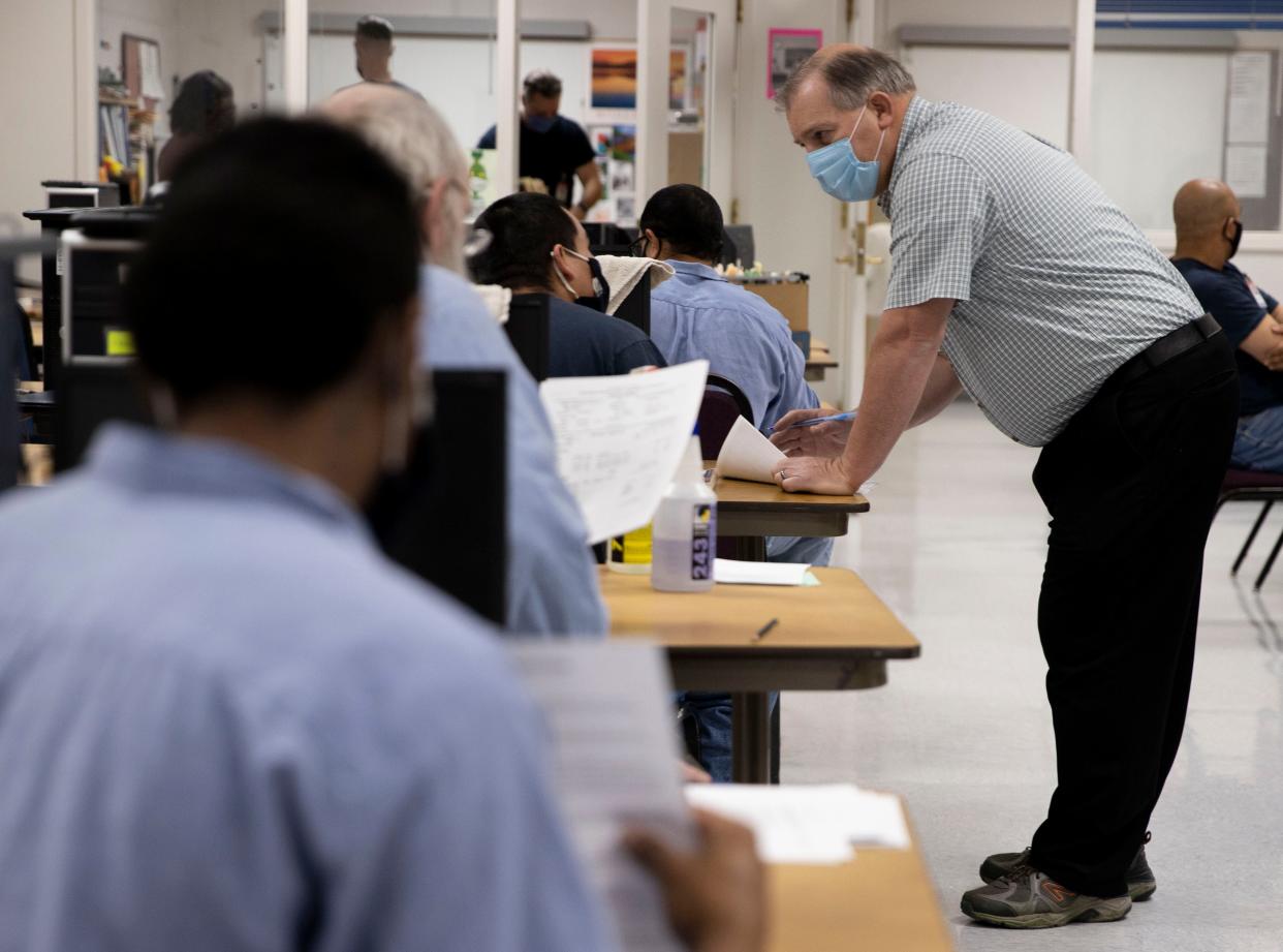 El instructor Garth Johnson (der.) trabaja con adultos bajo custodia en la Institución Correccional de Snake River en Ontario, Oregon, el jueves 12 de mayo de 2022.