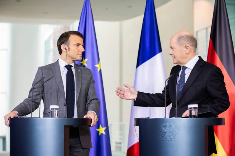 French President Emmanuel Macron (L) and German Chancellor Olaf Scholz speak during a press statement after their meeting in the Federal Chancellery. Christoph Soeder/dpa