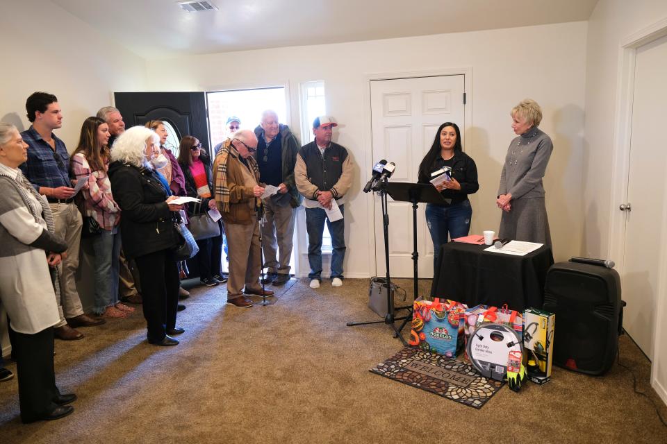 Ann Felton Gilliland, chairman and CEO of Central Oklahoma Habitat for Humanity, right, leads the dedication ceremony for Ana Villalobos's home, the final one in Habitat's Stephen Florentz Legacy Estates addition.