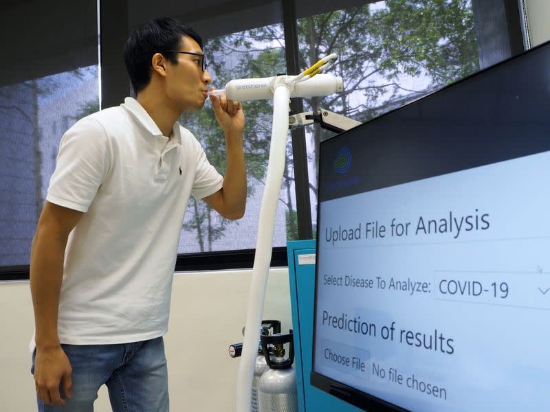 A staff member demonstrates the usage of Breathonix breathalyzer test kit in Singapore