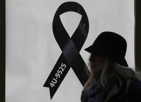 A woman walks past a black ribbon commemorating the 150 victims of Germanwings flight 4U 9525 outside Cologne's Cathedral, April 17, 2015. REUTERS/Wolfgang Rattay