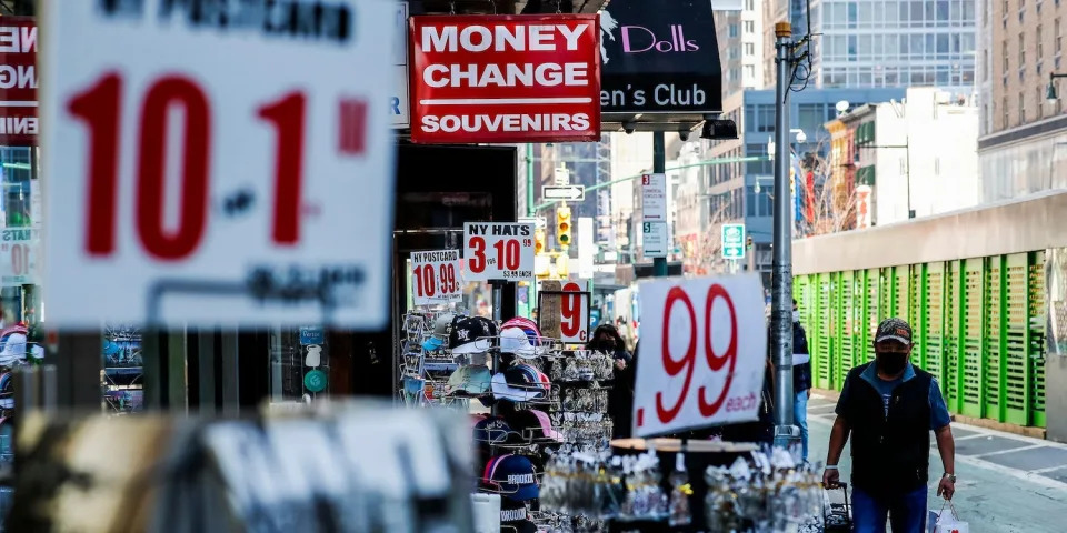 A man walks past shop signs showing offers. It&#39;s an indicator of the rising cost of living.