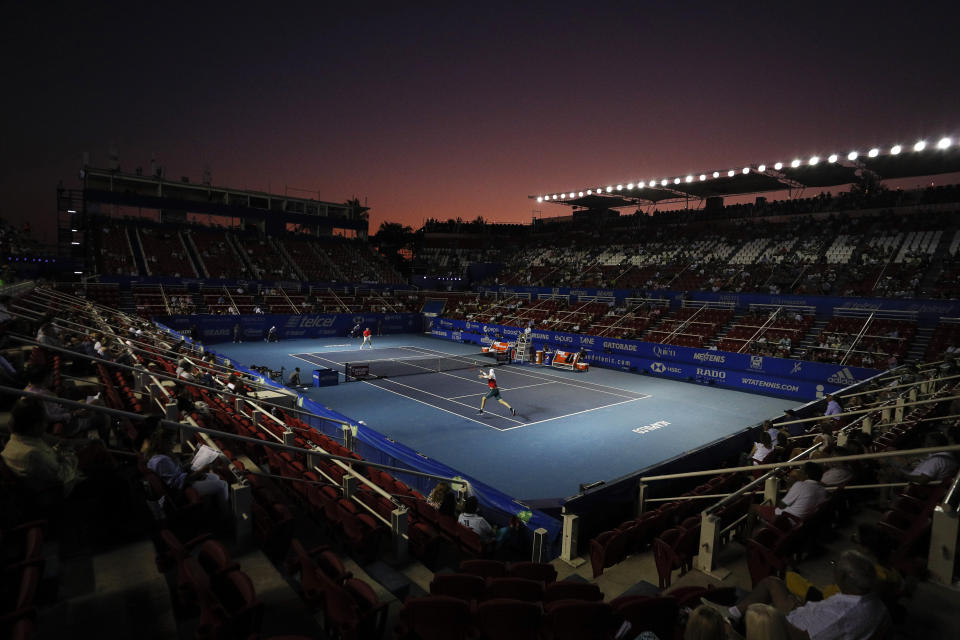 FILE - In this Feb. 28, 2020, file photo, John Isner of the U.S., front, returns a ball in his semifinal match against Taylor Fritz of the U.S. at the Mexican Tennis Open in Acapulco, Mexico. According to an email obtained by The Associated Press on Monday, May 4, the WTA and ATP professional tours, the groups that run the four Grand Slam tournaments and the International Tennis Federation are expected to establish eligibility rules that will factor in the players’ rankings and past prize money earnings. (AP Photo/Rebecca Blackwell, File)