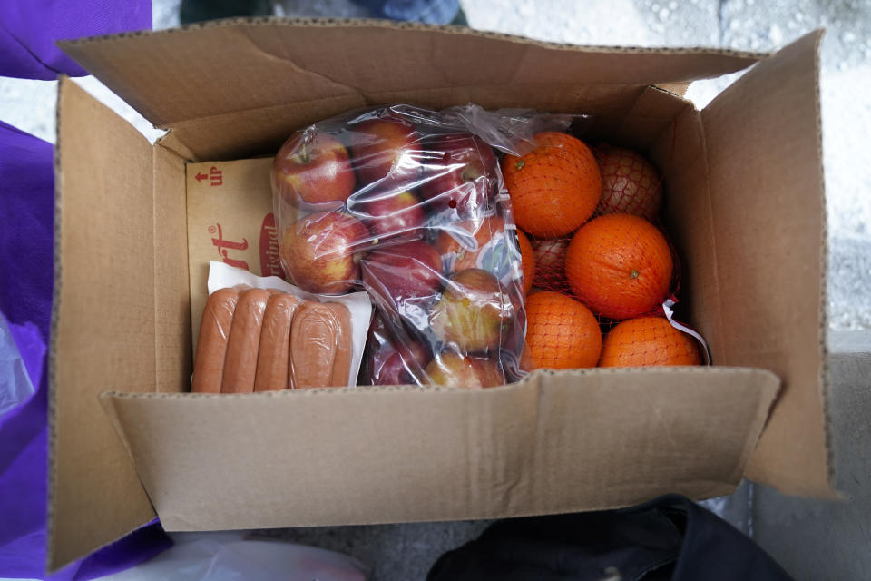 A USDA Farmers to Families Food Box is seen at a Des Moines Area Religious Council mobile food pantry stop at the downtown bus station, Thursday, Feb. 18, 2021, in Des Moines, Iowa. Agricultural groups and anti-hunger organizations are pushing the Biden administration to continue the Farmers to Families Food Box program launched by President Donald Trump that spent $6 billion to prevent farmers from plowing under food and instead provide it to millions of Americans left reeling by the coronavirus pandemic. (AP Photo/Charlie Neibergall)