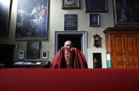 Rev. Mario Carminati takes off his vest after celebrating Mass inside the Santissima Redentore church in Seriate, near Bergamo, Italy, Sunday, Sept. 27, 2020. As the world counts more than 1 million COVID victims, the quiet of everyday life and hum of industry has returned to Bergamo, which along with the surrounding Lombardy region was the onetime epicenter of the outbreak in Europe. But the memory of those dark winter days, and the monumental toll of dead they left behind, has remained with those who survived only to see the rest of the world fall victim, too. (AP Photo/Antonio Calanni)