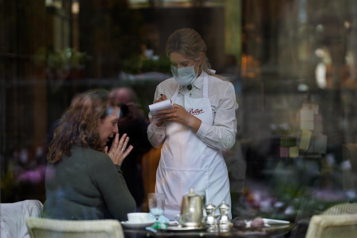 YORK, ENGLAND - OCTOBER 18: A woman places her order as she visits Betty's Tea Rooms on October 18, 2020 in York, England. York city has become another of England’s high risk areas placed under 'Tier 2' coronavirus lockdown measures as Government data indicates the R number range for the whole of the UK had increased slightly from between 1.2 and 1.5 last week to 1.3 and 1.5. Most notably the change will introduce a ban on people from different households from mixing anywhere indoors, prompting particular concern within the already badly-affected hospitality industry. (Photo by Ian Forsyth/Getty Images)