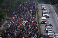 Migrants, many from Central American and Venezuela, walk along the Huehuetan highway in Chiapas state, Mexico, early Tuesday, June 7, 2022. The group left Tapachula on Monday, tired of waiting to normalize their status in a region with little work and still far from their ultimate goal of reaching the United States. (AP Photo/Marco Ugarte)