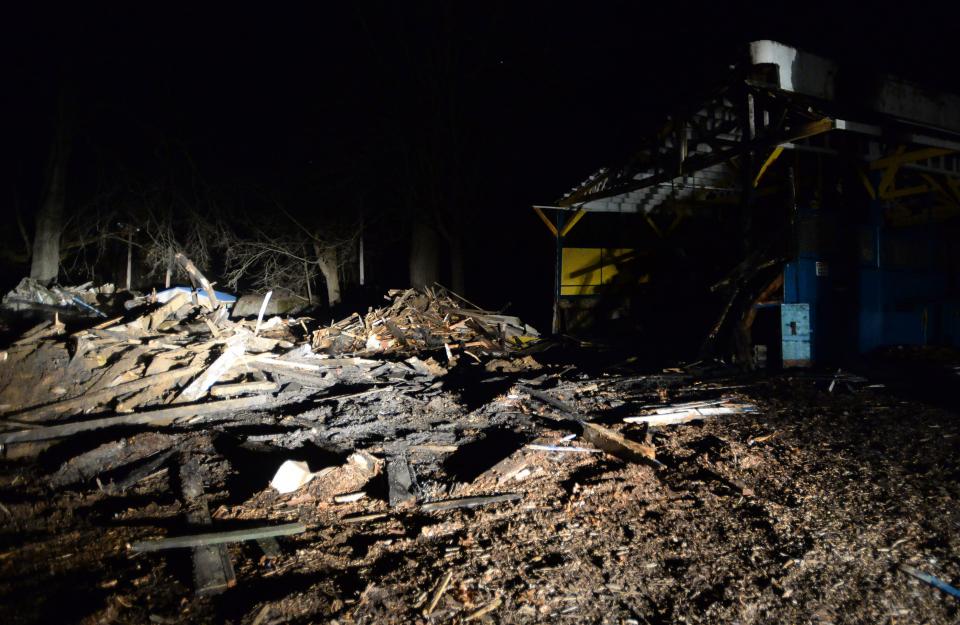 Piles of wood smolder where the Blue Streak roller coaster once stood on Jan. 4, 2022, at the former Conneaut Lake Park in Summit Township, Crawford County. The entrance and exit to the old coaster can be seen at right. The coaster was being dismantled when fire broke out earlier in the day.