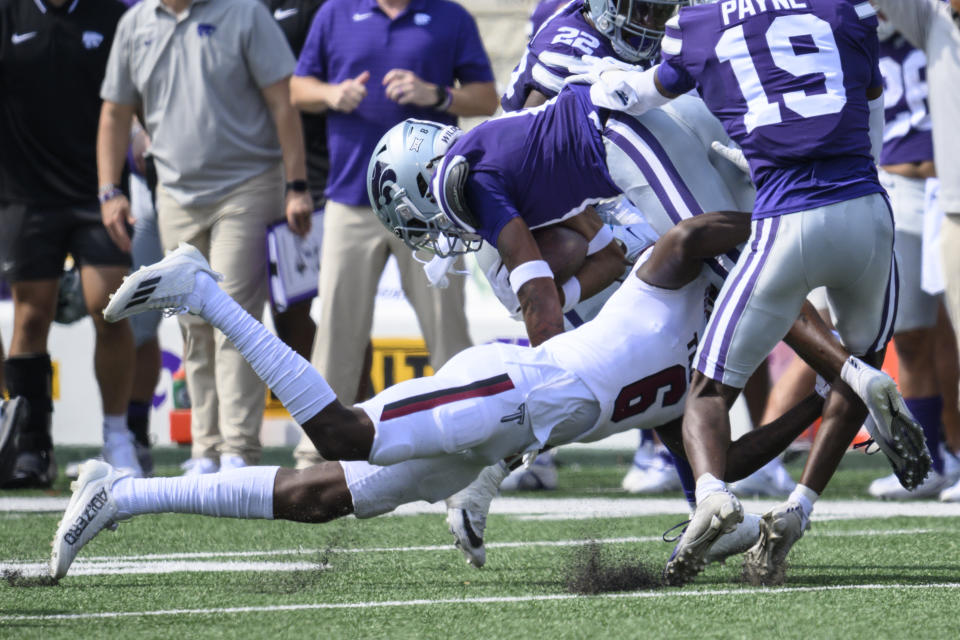 Troy wide receiver Chris Lewis (6) tackles Kansas State cornerback Will Lee III, after Lee intercepted a pass during the first half of an NCAA college football game in Manhattan, Kan., Saturday, Sept. 9, 2023. (AP Photo/Reed Hoffmann)