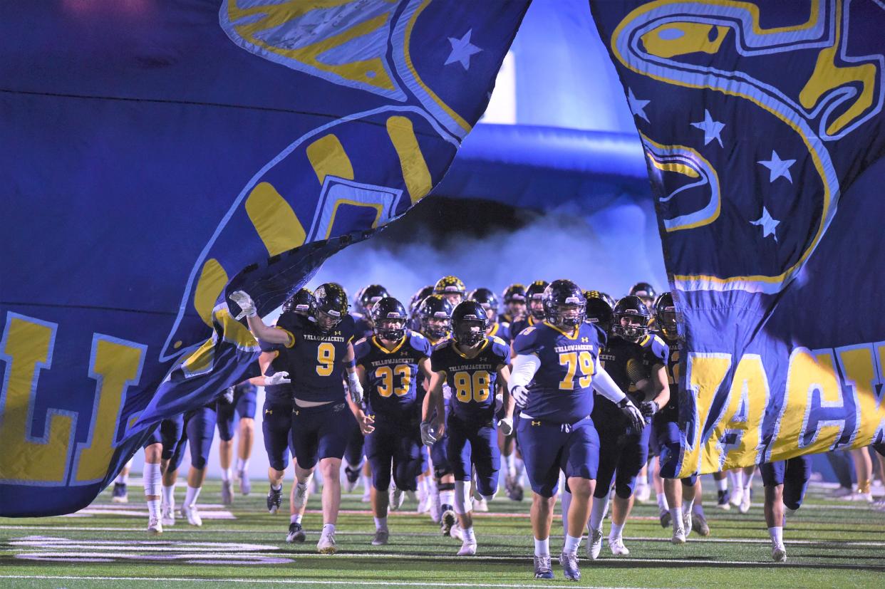 The Stephenville football team breaks through the banner as they run on the field before last season's Region II-4A Division I final against Melissa at Pennington Field in Bedford.