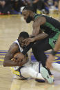 Golden State Warriors forward Draymond Green, bottom, holds onto the ball under Boston Celtics guard Jaylen Brown during the first half of Game 5 of basketball's NBA Finals in San Francisco, Monday, June 13, 2022. (AP Photo/Jed Jacobsohn)