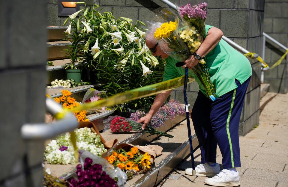 Sharon Reynolds, a U.S. Army veteran places flowers on the steps of the Old National Bank Tuesday, April 11, 2023 after a mass shooting Monday morning that left six dead, including the shooter, and another 8 injured. 