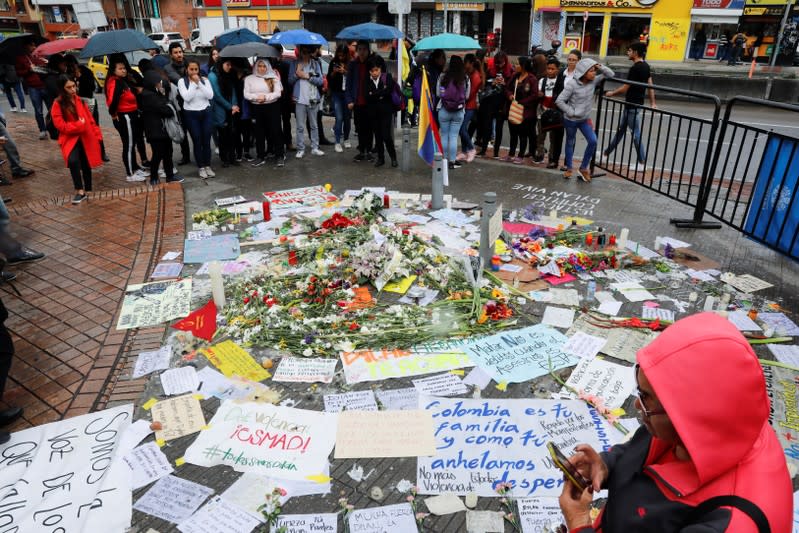 People gather around placards, candles and flowers to honour Dilan Cruz, a teenage demonstrator who died after being injured by a tear gas canister during an initial strike last week, in Bogota