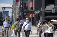 People wearing face masks to help curb the spread of the coronavirus cross an intersection in Tokyo Thursday, Aug. 5, 2021. Tokyo reported 5,042 new daily coronavirus cases on Thursday, hitting a record since the pandemic began as the infections surge in the Japanese capital hosting the Olympics. (AP Photo/Kantaro Komiya)