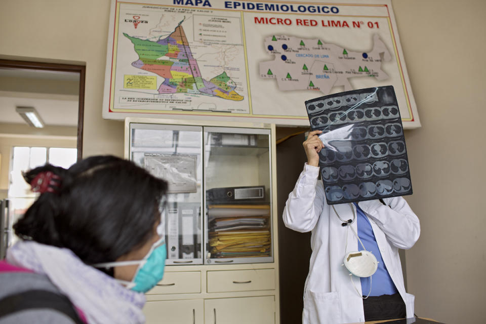 <p>Shortly after getting on HIV medication, Tamara is diagnosed with tuberculosis. Here, a doctor examines an x-ray of her lungs. (Photo: Danielle Villasana) </p>