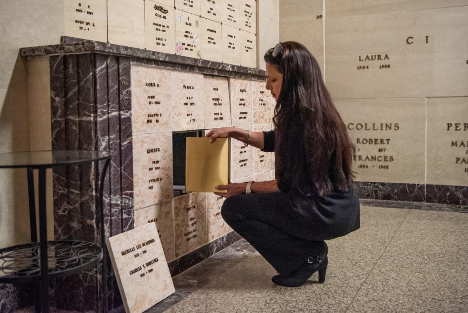Karla DeColli, a family services counselor at Sunset Memorial Park, inters the remains of Michelle McGinnis inside the cemetary's mausoleum on Saturday, March 21, 2020. [MICHELE HADDON / PHOTOJOURNALIST]