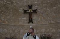 Father Iosif Skender, a Maronite priest, holds a wine goblet, which in Christian tradition signifies Jesus's blood, during a service at the Church of St. George in Kormakitis