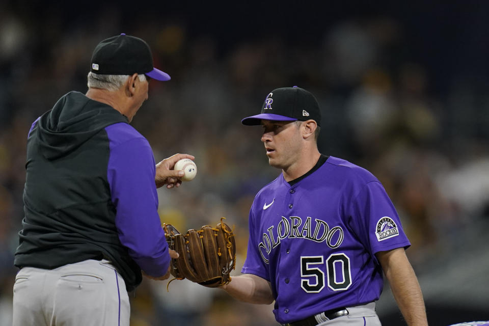 Colorado Rockies manager Bud Black, left, hands the ball to pitcher Ty Blach during a pitching change in the fifth inning of the team's baseball game against the San Diego Padres on Friday, June 10, 2022, in San Diego. (AP Photo/Gregory Bull)