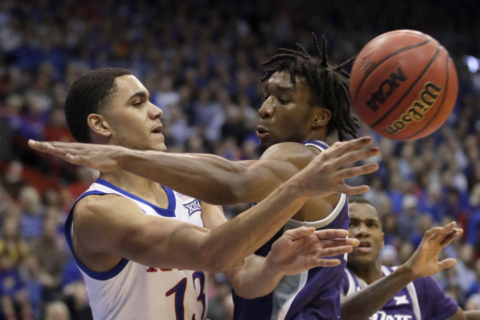 Kansas guard Tristan Enaruna (13) passes around Kansas State forward Xavier Sneed, right, during the second half of an NCAA college basketball game in Lawrence, Kan., Tuesday, Jan. 21, 2020. Kansas defeated Kansas State 81-59. (AP Photo/Orlin Wagner)