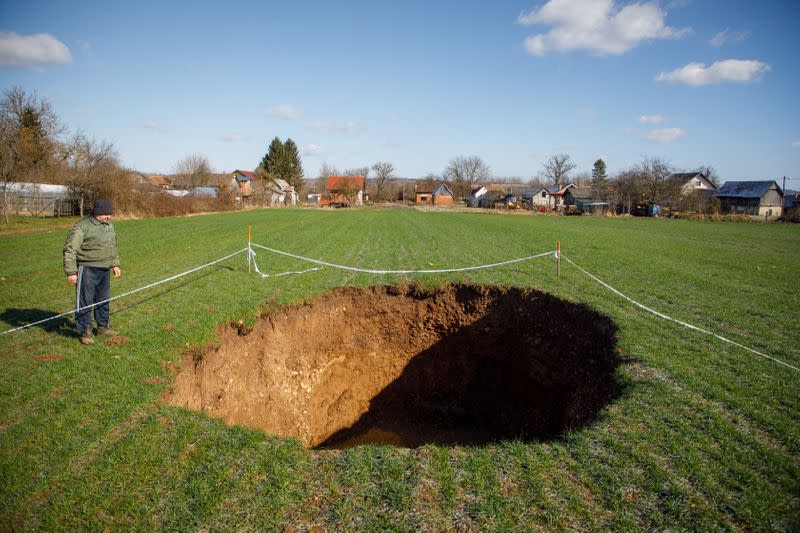 Man is seen next to sinkhole is seen in village Mecencani