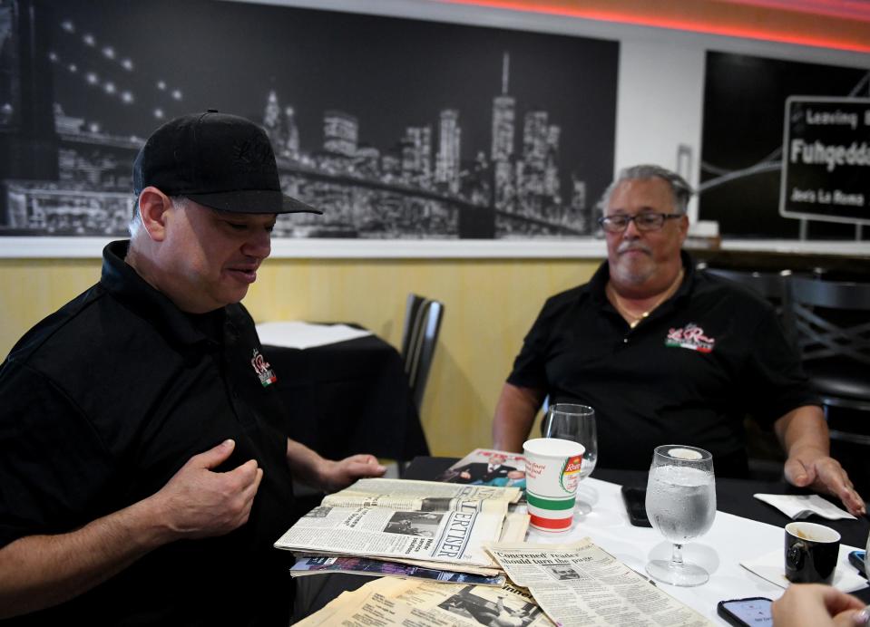 Joe and Vinny Bellia look at newspaper clippings of previous articles written over the years at Joe's La Roma Ristorante Tuesday, Aug. 15, 2023, in Fruitland, Maryland.
