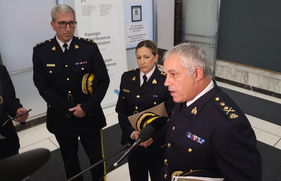 Royal Canadian Mounted Police (RCMP) commissioner Michael Duheme, right, RCMP assistant commissioner Brigitte Gauvin, and RCMP deputy commissioner Mark Flynn speak to reporters after testifying at the Foreign Interference Commission in Ottawa on Thursday, Oct. 3, 2024.