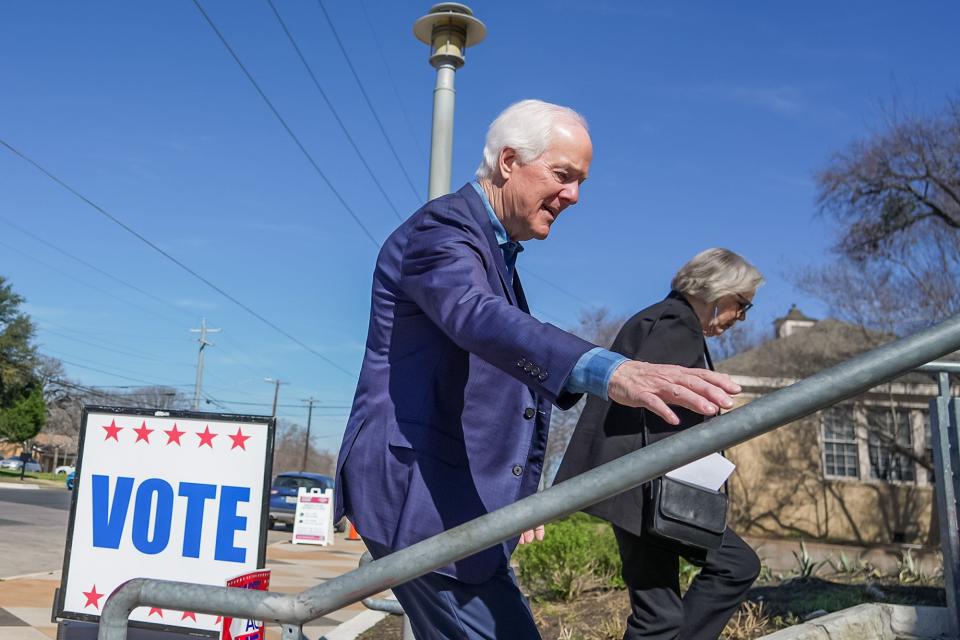 U.S. Sen. John Cornyn, R-Texas, and his wife, Sandy, enter the George Washington Carver Branch library on Tuesday to cast their ballots in the Texas primary.