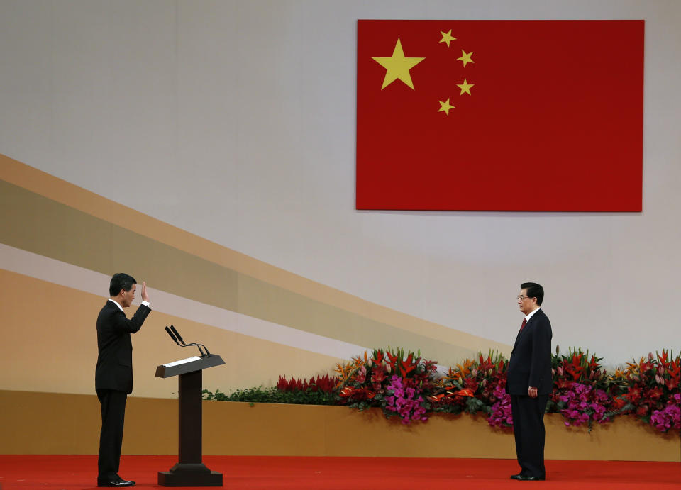 Chinese President Hu Jintao, right, administers the oath to Hong Kong's new Chief Executive Leung Chun-ying, left, as he is sworn in for a five-year term in office at the Hong Kong Convention and Exhibition Center Sunday, July 1, 2012. Hong Kong's new Beijing-backed leader was sworn in on Sunday amid a rising tide of public discontent over widening inequality and lack of full democracy in the semiautonomous southern Chinese financial center. (AP Photo/Vincent Yu)
