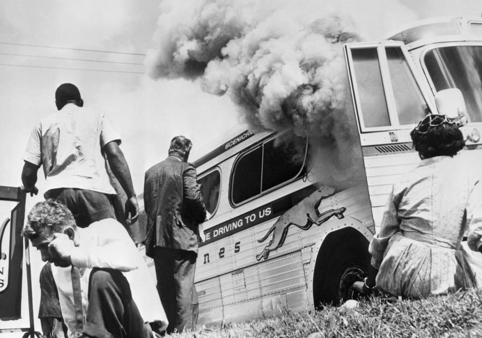 <div class="inline-image__caption"><p>Members of the "Freedom Riders," a group sponsored by the Congress of Racial Equality (CORE), sit on the ground after the bus was set afire by a mob of white people in Aniston, Alabama on May 14, 1961 </p></div> <div class="inline-image__credit">Bettmann/Getty Images</div>