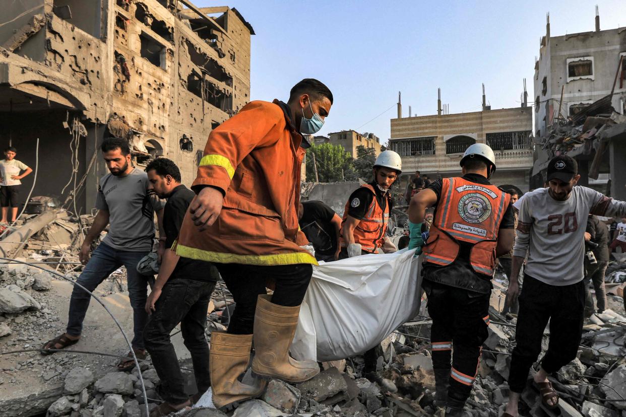 Palestinian civil defence members carry the body of a victim that was killed during Israeli bombardment of Khan Yunis, southern Gaza (AFP/Getty)