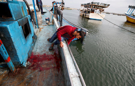 A man inspects a boat in which a Palestinian was killed at the seaport of Gaza City February 26, 2018. REUTERS/Mohammed Salem