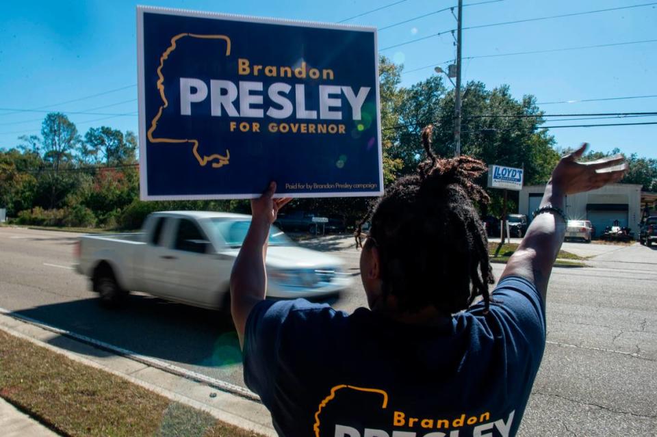 A Brandon Presley supporter waves a sign outside Orange Grove Community Center, a voting precinct in Harrison County, on Election Day, Tuesday, Nov. 7, 2023.