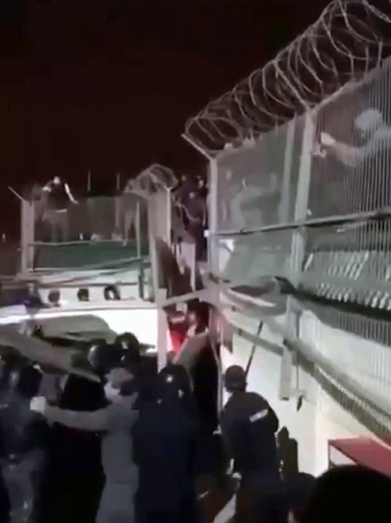 En esta captura de un video publicado en el canal de Telegram @askrasul el 29 de octubre de 2023, se muestran a miembros de las fuerzas del orden impidiendo que los manifestantes rompan la valla de un aeropuerto en Makhachkala. 