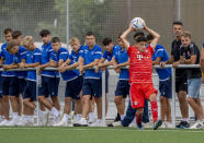 A youth players of Bayern Munich throws the ball while members of another team watch in Nuremberg, Germany, Friday, July 29, 2022. Some of Europe's best young soccer players from the under-17 teams of Chelsea, Bayern Munich, Bologna and other international clubs contest the Walther Bensemann Memorial Tournament in Nuremberg, where they also learn the dangers of intolerance by meeting Holocaust survivors, attending workshops and taking part in excursions. (AP Photo/Michael Probst)