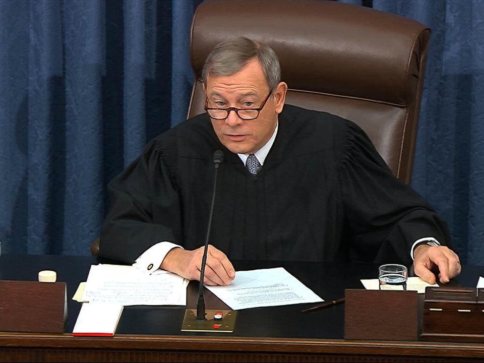 In this image from video, presiding officer Chief Justice of the United States John Roberts gets a card with the question submitted by Sen. Rand Paul, R-Ky., aside as declines to read the question as written during the impeachment trial against President Donald Trump in the Senate at the U.S. Capitol in Washington, Thursday, Jan. 30 2020. (Senate Television via AP)