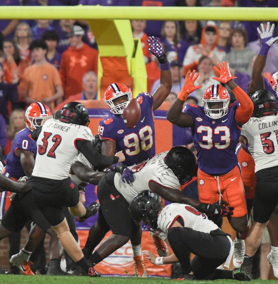 Clemson defensive end Myles Murphy (98) and defensive tackle Ruke Orhorhoro (33) pressure Louisville kicker James Turner (32) during the third quarter at Memorial Stadium in Clemson, South Carolina Saturday, Nov. 12, 2022.   