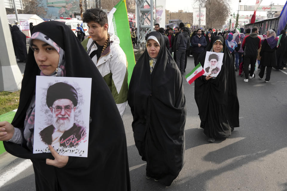 Iranian demonstrators carry posters of the Supreme Leader Ayatollah Ali Khamenei and their national flag during the annual rally commemorating Iran's 1979 Islamic Revolution, in Tehran, Iran, Saturday, Feb. 11, 2023. Iran on Saturday celebrated the 44th anniversary of the 1979 Islamic Revolution amid nationwide anti-government protests and heightened tensions with the West. (AP Photo/Vahid Salemi)