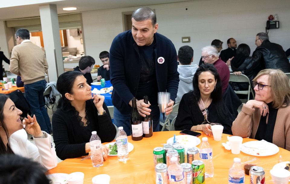 Ty Safaryan serves wine to visitors during a day of events in Clintonville commemorating the Armenian genocide, which began April 24, 1915.