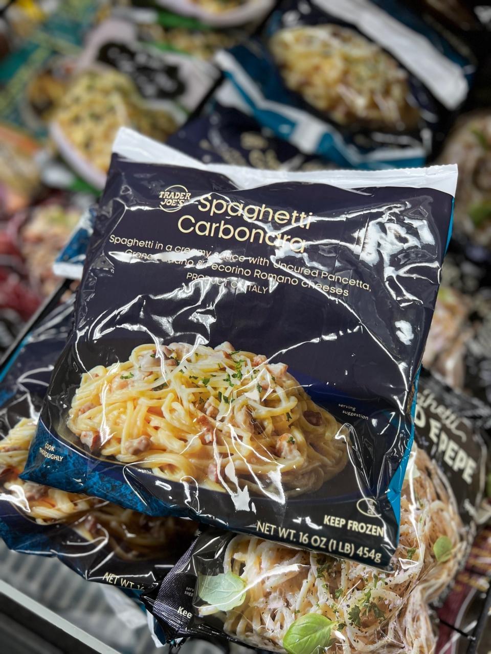 Package of Trader Joe's Spaghetti Carbonara in a freezer with various frozen foods in the background